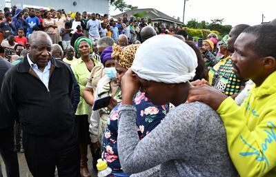 South Africa's President Cyril Ramaphosa, left, with grieving family members. AP