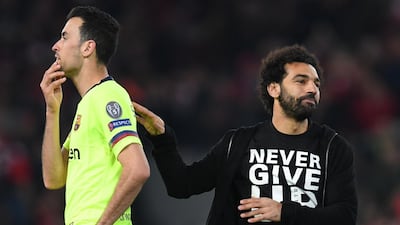 Mohamed Salah passes Barcelona's Spanish midfielder Sergio Busquets as he celebrates. AFP