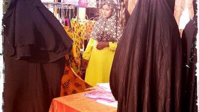 Day trip with friends to the Western Region and the Mazayin Dhafra Camel Festival, 220 kms west of Abu Dhabi on December 20, 2013.Local women peruse a booth selling ladies dresses. Picture taken with the Hipstamatic app for the iPhone. Liz Claus / The National