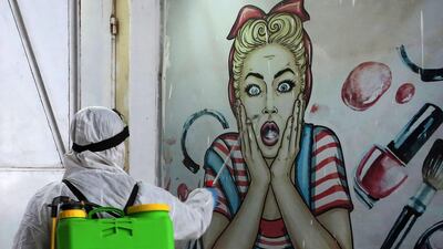 A volunteer disinfects a shop in Baghdad's Bayaa neighbourhood. AFP