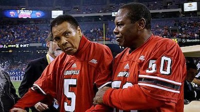 This is a Jan. 2, 2013 file photo of Muhammad Ali, left, and NFL great Tom Jackson as they arrive for the coin toss before the Sugar Bowl NCAA college football game in New Orleans. Muhammad Ali, who has been suffering with Parkinson’s disease, is enjoying life and doing well, two of his daughters said Tuesday Nov. 25, 2014. AP Photo/Bill Haber
