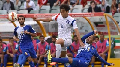 Nam Tae-hee of South Korea fights for the ball with Fahad Al Hajeri of Kuwait during their Asian Cup Group A match on Tuesday in Canberra. Mark Graham / AFP