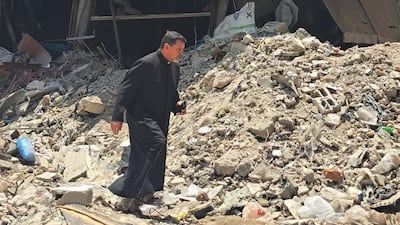 Fr Carlos Ferrero, a Catholic priest, in the rubble surrounding the church. Photo: Holy Family Church
