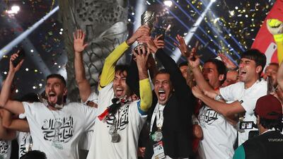 Iraqi national football team players lift the trophy as they celebrate at the stadium in Basra. AP