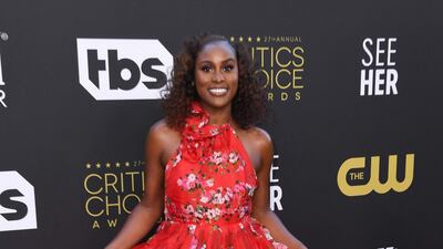 US actress Issa Rae arrives in a red floral gown by Carolina Herrera. AFP