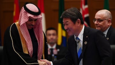 At a meeting in Nagoya, Japan's Foreign Minister Toshimitsu Motegi shakes hands with Saudi Arabia's Foreign Minister Prince Faisal bin Farhan to mark the handover to the kingdom as future host of the G20 forum. Afp