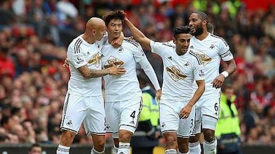 Ki Sung-Yeung of Swansea City celebrates scoring the opening goal with his team-mates during the Barclays Premier League match between Manchester United and Swansea City at Old Trafford on August 16, 2014 in Manchester, England. Alex Livesey/Getty Images