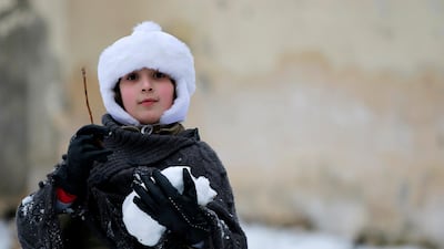 A girl carries a snow ball while playing in Aleppo January 11, 2015. Reuters