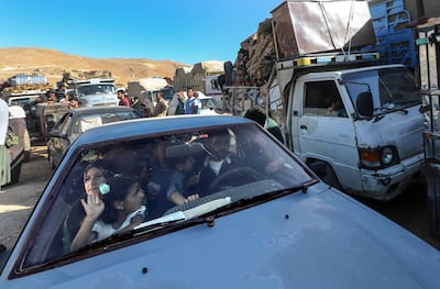 Syrian refugees sit inside their cars waiting to be allowed to cross from Lebanon into Syria to return home. EPA