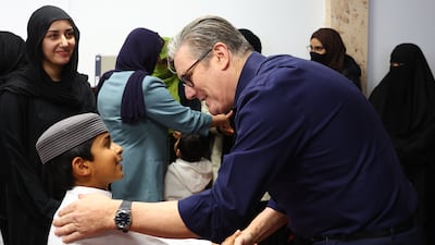 Prime Minister Keir Starmer greets a young boy during a visit to Peacehaven Mosque. PA