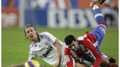 The Real Madrid midfielder Guti, left, and Atletico's Jose Antonio Reyes tangle for the ball.