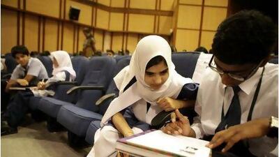 Pupils from Indian schools concentrate on questions related to Mahatma Gandhi and non-violence at the Indian Embassy in Abu Dhabi yesterday.