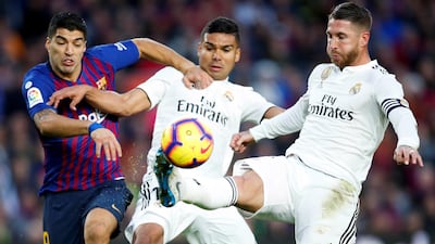 Real Madrid's Casemiro (C) and Sergio Ramos (R) in action against FC Barcelona's Luis Suarez (L) during a Spanish La Liga soccer match between FC Barcelona and Real Madrid at the Camp Nou stadium in Barcelona, northeastern Spain. EPA