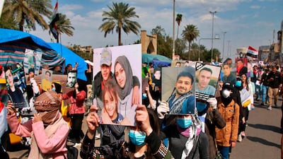 Anti-government protesters hold pictures of protesters who have been killed in anti-government demonstrations, during a rally in Baghdad, Iraq. AP Photo