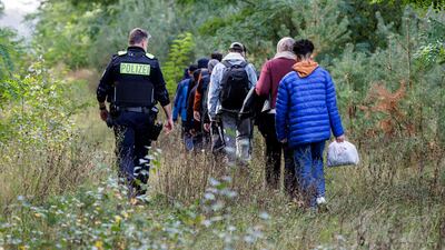 German police escort migrants near the border with Poland. AFP