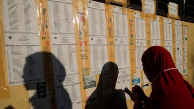 Filipinos look for their names and corresponding voting precincts on a board at a school in Manila, Philippines. EPA