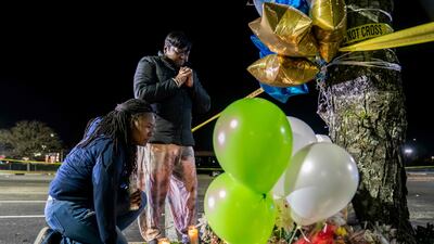 Lashana Hicks joins other mourners at a memorial for those killed in a fatal shooting. Getty Images / AFP