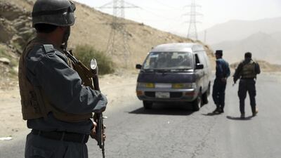 Afghan police officers search a vehicle at a checkpoint on the Ghazni highway, west of Kabul. AP