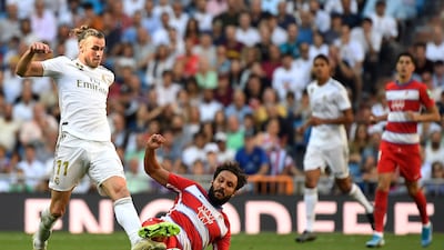 Real Madrid's Welsh forward Gareth Bale, left, is challenged by German Sanchez of Granada. AFP