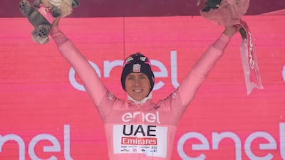 Slovenian rider Tadej Pogacar celebrates on the podium in the overall leader's pink jersey. AFP