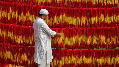 A workshop owner checks freshly-dyed Kalawa threads, a traditional sacred orange-yellow thread used in Hindu rituals, ahead of the Navratri festival at Lalgopalganj village, 45km from Allahabad. AFP