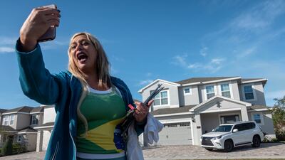 A Brazilian poses for a photo outside the house where Mr Bolsonaro is reportedly staying in Reunion, Florida. EPA