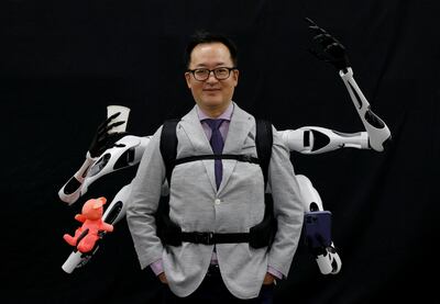 Masahiko Inami of the University of Tokyo poses with the 'Jizai Arms' at his lab during a demonstration. Reuters