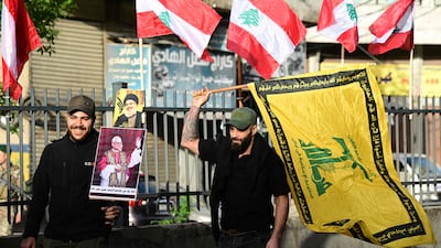 Lebanese men holding a poster of Pope Leo XIV and a Hezbollah flag in Beirut last week. AFP