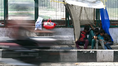 Children take shelter under a makeshift canopy in New Delhi. AFP