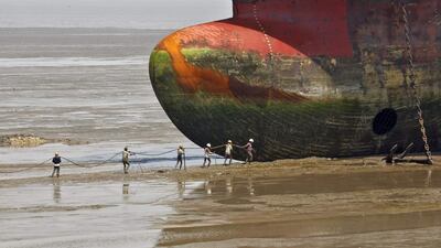 Workers carry a rope line to fasten a decommissioned ship at the Alang shipyard in the western Indian state of Gujara. Amit Dave / Reuters