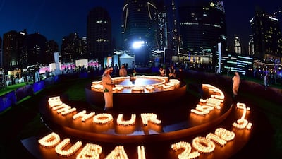 People light candles after the building lights were switched off for the Earth Hour environmental campaign in Dubai on March 24, 2018. Earth Hour, which started in Australia in 2007, is set to be observed by millions of supporters in 187 countries, who will turn off their lights at 8.30pm local time in what organisers describe as the world's "largest grassroots movement for climate change". / AFP PHOTO / Giuseppe CACACE