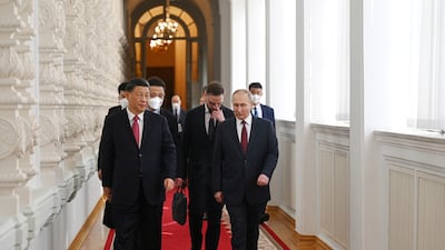 Mr Putin and Mr Xi walk through the Kremlin. Reuters