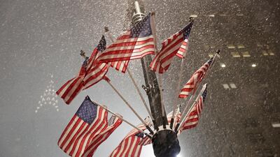 US flags flutter in the wind as snow falls near Grand Central Terminal in Manhattan. Reuters