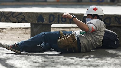A member of the red cross protects himself from rubber bullets. Reuters