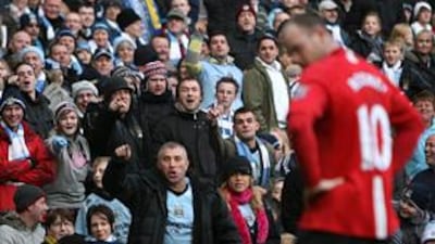 Manchester City fans taunt United striker Wayne Rooney during the derby at Eastlands last season. United won the game 1-0.