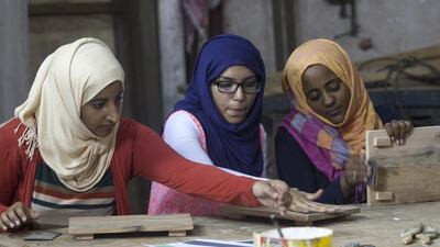 Members of the Beyond Borders team during week five of the show. Mariam Al Kuwaiti and Fatima Abdulla Farah painting on recycled wood. Photo Courtesy of Beyond Borders