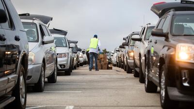 People line up in their cars to receive Thanksgiving meal boxes that include turkey and pantry items during the largest food giveaway of the Tarrant Area Food Bank at AT&T Stadium parking lot in Arlington, Texas. Star-Telegram via AP