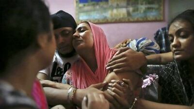 Surinder Kaur, centre, the wife of Seeta Singh who was killed in the shooting attack at a Sikh temple in Wisconsin, is comforted by her son Armeet and daughter Sarabjit, right, at the family home in New Delhi.
