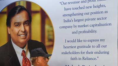 A shareholder walks past a poster of India's richest man and oil-to-telecom conglomerate Reliance Industries chairman Mukesh Ambani. Last week, Aramco’s inaugural earnings call covered preliminary plans to pay $15bn for 20 per cent of Reliance Industries’ refining and petrochemicals business. AFP