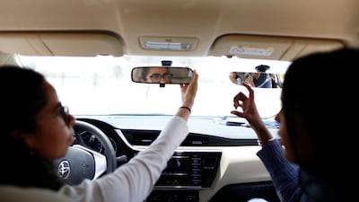Maria Al Faraj, left, adjusts her rear-view mirror. Ahmed Jadallah / Reuters