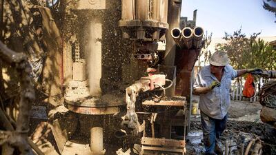 Drill helper Jimmy Payne of Diamond Well Drillers, checks on the drill progress as they work to deepen the Brady family well. Max Whittaker / Reuters