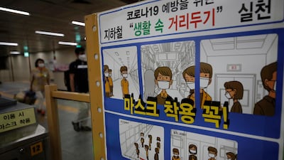 Passengers wearing face masks walk near a banner displaying precautions against the coronavirus at the subway station in Seoul, South Korea. AP Photo