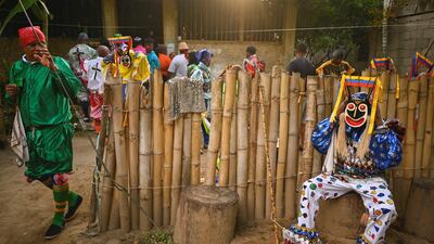 A member of the Brotherhood of the Diablos Danzantes de Chuao (Dancing Devils of Chuao) arranges his mask during the Corpus Christi festival in the town of Chuao, Venezuela. Reuters