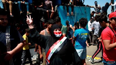 A woman flashes the victory sign during ongoing Anti-government protests in Baghdad, Iraq. AP Photo