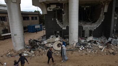 Palestinians pass the war-damaged Al Shifa Hospital in Gaza city, northern Gaza. EPA