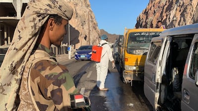 Members of Yemen's Southern Transitional Council man a checkpoint while workers disinfect vehicles at the entrance of Mualla, a district of the southern province of Aden, amid the Covid-19 pandemic on May 10, 2020. AFP