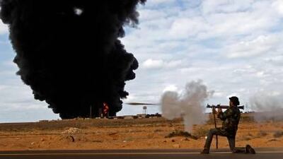 A rebel fighter fires a rocket-propelled grenade launcher in front of a gas storage terminal during a battle on the road between Ras Lanuf and Bin Jiwad. Goran Tomasevic / Reuters