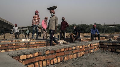 Workers construct funeral pyre plinths on barren land near a crematorium in New Delhi, India. Bloomberg