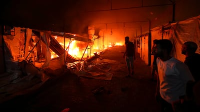 Palestinians watch the fire burn through the courtyard of Al Aqsa Hospital in Deir Al Balah. AP