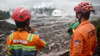 Rescuers monitor the flow of volcanic materials from the eruption of Mount Semeru. AP